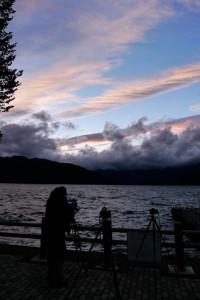 夕暮れの空を待つカメラたちの図。三脚が3本並んで空の色と雲の形がよくなるのを待ってます