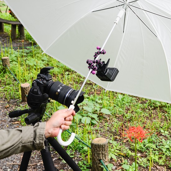 コンビニなどで売っている半透明の白い傘の柄に、ミニ三脚（ ゴリラポッド ）でストロボを取り付ける。
