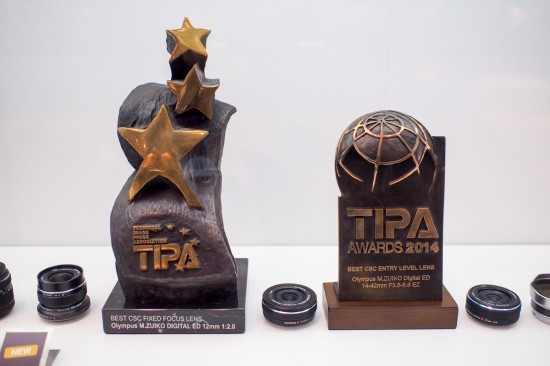 TIPA アワードの受賞トロフィーが対象機種とともに展示されていた。オリンパスブース。