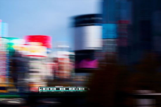 焦点距離：70 mm / シャッター速度：1/2秒 / 絞り数値：F16 / ISO感度：125　流し撮りの定番スポット、新宿駅近くの陸橋で撮影。デジタル時代に昼間から1/2秒で撮影できるとは。雑多な街も流し撮りでカラフルな背景となった。